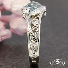 a close up of a ring with flowers in the background