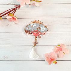 a white table with pink flowers and a brooch on it's back side