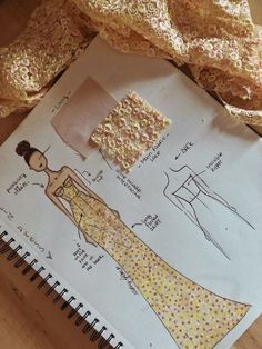 an open notebook with some paper on top of it next to lace and cloths