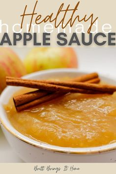 a white bowl filled with apple sauce and cinnamon sticks