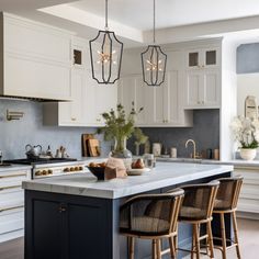 a kitchen with white cabinets and an island in the middle is surrounded by stools