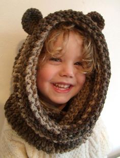 a little boy wearing a bear hat and scarf