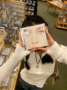 a woman holding up a cd in front of her face