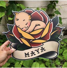 a hand holding up a sticker with a baby on it's chest and the words, myx