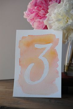 there is a card with the number seven on it and flowers in front of it