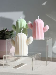 three candles in the shape of cactuses sitting on a table