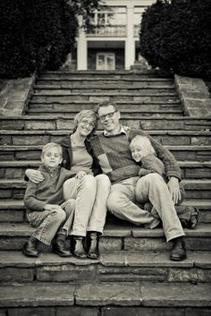 a family sitting on steps in front of a building