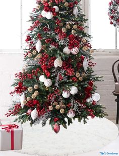 a christmas tree decorated with red and white balls, pine cones, ornaments and snowflakes