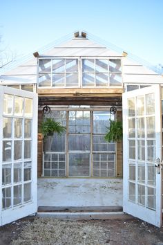 an old greenhouse with white doors and windows