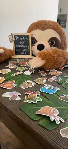 a stuffed animal sitting on top of a wooden table with lots of stickers around it