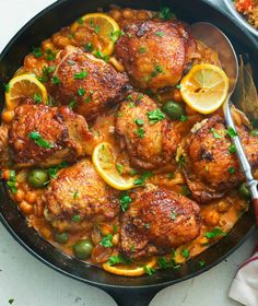 a skillet filled with chicken, beans and lemons