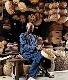 a man sitting on a bench in front of baskets