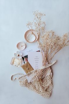 the contents of a purse laid out on top of each other, including an envelope and some flowers