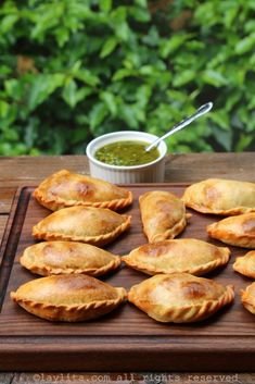 small pastries on a wooden tray with dipping sauce