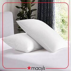 two white pillows sitting on top of a bed