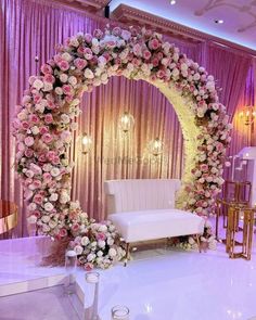 a white couch sitting under a flower covered arch