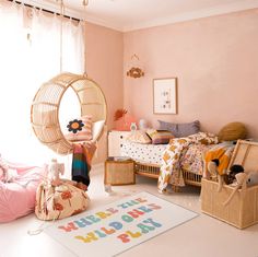 a child's bedroom with pink walls and furniture, including a hammock chair