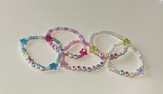 -Hand made beaded elastic bracelets. -Tomorrow x Together (txt) members different colour bracelets with matching stars. -Kai - white and clear -Soobin - purple and pearl with pink hearts -Yeonjun - pink and pearl -Beomgyu - yellow and pearl  -Taehyun - blue and pearl  -Approximately 8.5cm in diameter, all comfortably fit a 16cm measured wrist. *Default untracked shipping in Australia unless tracked selected* White Kpop Beaded Bracelets With Letter Beads, White Letter Beads Bracelet Kpop Style, White Beaded Bracelets With Letter Beads Kpop Style, White Beaded Kpop Bracelets, Kpop Style White Jewelry With Letter Beads, White Kpop Style Jewelry With Letter Beads, White Star Bracelets For Friendship, White Star-shaped Bracelet With Colorful Beads, Txt Members