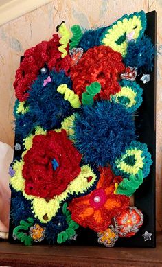 there are many crocheted flowers on the shelf