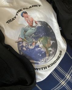 a t - shirt with the image of a man sitting on top of a globe