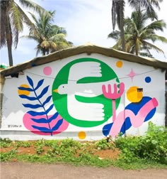 a large mural on the side of a building with palm trees in the back ground