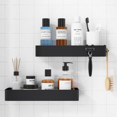 two black shelves are holding different types of bathroom products and toothbrushes on them