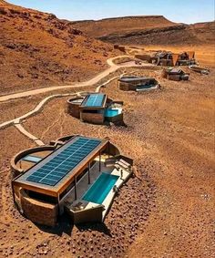 there are many small solar panels on the ground in the desert with no people around them