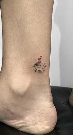 a small tattoo on the ankle of a woman with a cup of coffee in it