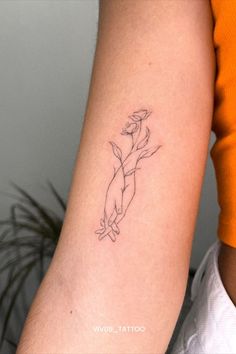 a woman's arm with a small tattoo on the left side of her arm