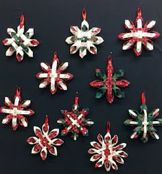 six christmas ornaments are arranged on a black surface with red, white and green ribbons