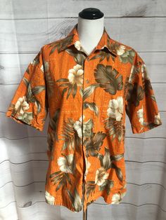 "Vintage Mens Orange Floral Hawaiian Shirt Mens Hawaiian Tropical Shirt by Pierre Cardin Color is orange with brown and beige Hibiscus and palm fronds Short sleeve Buttons up front One chest pocket on L Straight hem  Materail is 100% cotton Cotton is great Fabric for the summer  Mens size Large Measurements Chest 49\" Length 30\" Mens shirt but can easily be considered Unisex Very good vintage condition with no noted flaws Garment has been laundered and is ready to wear. Even though this is cott Orange Collared Vacation Shirt, Orange Collared Shirt For Vacation, Orange Short Sleeve Shirt For Vacation, Orange Collared Shirt With Floral Print, Orange Floral Print Collared Shirt, Orange Printed Casual Hawaiian Shirt, Orange Floral Print Shirt For Vacation, Casual Orange Shirt With Floral Print, Casual Orange Floral Print Shirt