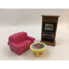 a toy couch, table and television set on a white background with room for text