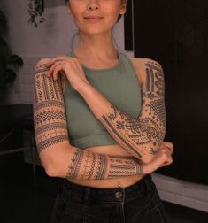 a woman with tattoos on her arms posing for the camera