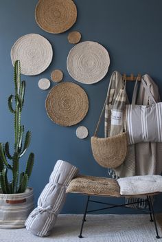 a room with blue walls and white rugs on the floor next to a cactus