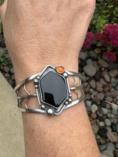 This cuff was made during the full harvest moon and the lunar eclipse. It's imbued with power and goodness. A sterling silver band with black onyx and a small amber cabochon. Hand stamped sterling silver details. 6 inches. Unique Adjustable Black Bangle, Unique Black Adjustable Bangle, Black Spiritual Cuff Bracelet As Gift, Spiritual Black Cuff Bracelet As Gift, Spiritual Black Cuff Bracelet For Gift, Black Carnelian Jewelry For Gifts, Unique Handmade Black Bangle, Spiritual Silver Obsidian Bracelet, Black Sterling Silver Bangle