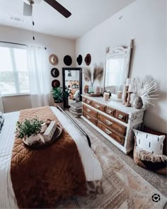 a bed room with a neatly made bed and a large mirror on the wall above it