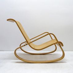 a wooden rocking chair sitting on top of a white floor