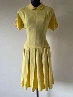 "1960s Yellow Fit and Flare Dress. Featuring Peter Pan collar, short sleeves, box pleat skirt. Original metal 'Grand' zipper at back of garment. Measurements: Bust: 36\" Waist: 30\" Hips: Open Length:  39\" Excellent vintage condition." 1950s Short Sleeve Vintage Fashion Dress, 1950s Short Sleeve Dress For Vintage Fashion, 1950s Style Short Sleeve Vintage Dress, 1950s Style Vintage Fashion Dress With Short Sleeves, 1950s Style Lined Short Sleeve Dresses, 1950s Style Short Sleeve Lined Dress, Yellow Pleated Short Sleeve Dress, Fitted Short Sleeve 1950s Dress, Classic Short Sleeve Dress With Pleated Skirt