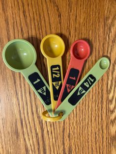 three measuring spoons and two measuring cups on a table