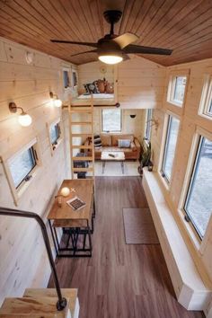 the interior of a tiny house with wooden walls and ceilings, wood flooring, and windows