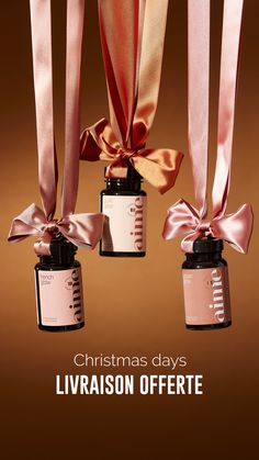 three bottles with pink ribbon tied around them and the words christmas days livraison offer