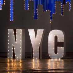 the word nyc spelled out in front of city lights