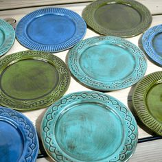 blue and green plates sitting on top of a wooden table