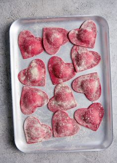 heart shaped cookies on a baking sheet ready to be baked in the oven for valentine's day