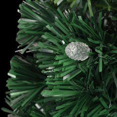 a close up of a pine tree with green needles and silver balls on it's branches