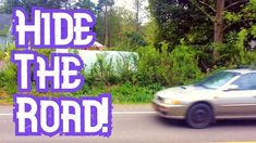 a car is driving down the road in front of some trees and bushes with an advertisement that reads hide the road