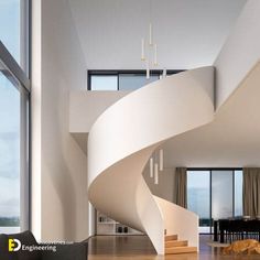 a living room filled with furniture and a spiral staircase in front of a large window