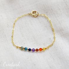 "Pride Bracelet - Rainbow Bracelet This bracelet is handmade with an array of gemstones (listed below) in between tiny gold or silver glass beads. It is available in sterling silver or 14kt gold fill. Please measure your wrist size before purchasing. If purchasing as a gift the adjustable size of 6.5 to 7.5\" fits most average women. This bracelet can also be made with the stones going in order of the Chakras. Please leave a note in the note to seller box at checkout saying you would like them a Rainbow Bracelet Jewelry For Healing, Adjustable Rainbow Gemstone Jewelry, Adjustable Rainbow Birthstone Jewelry, Pride Jewelry, Bracelet Emerald, Pride Jewellery, Bracelet Rainbow, Pride Bracelet, Gemstone List