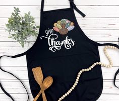 a black apron that says give turkeys on it with a wooden spoon next to it