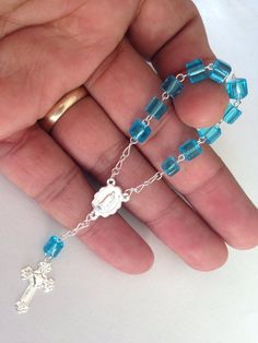 25 Rosarios pequeñitos de un decenario en color azul tono turquesa , son hechos a Mano con la Imagen de la virgen de Guadalupe , bañados en Plata y hechos de cubitos de vidrio , no plastico. Mide cerca de 4.5" pulgadas de largo y Los crystalitos importados son de 6 mm.La crucecitas tienen un corazoncito en el centro.Perfectos para communion, bautismo , quince.******************************************25 pc of beautiful minirosaries all hand made with glass beads imported from Czech Republic, I'm Handmade Blue Rosary For Jewelry Making, Handmade Blue Rosary With Cross, Handmade Blue Rosary With Cross Shape, Blue Cross Rosary For Gift, Blue Cross Rosary As Gift, Blue Spiritual Jewelry For First Communion, Blue Spiritual Rosary As A Gift, Pearl Bridal Comb, Mini Rosaries